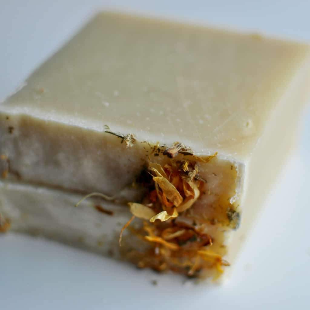 oatmeal bar soap using the cold process method, it's yellow with flowers on top and made with organic ingredients